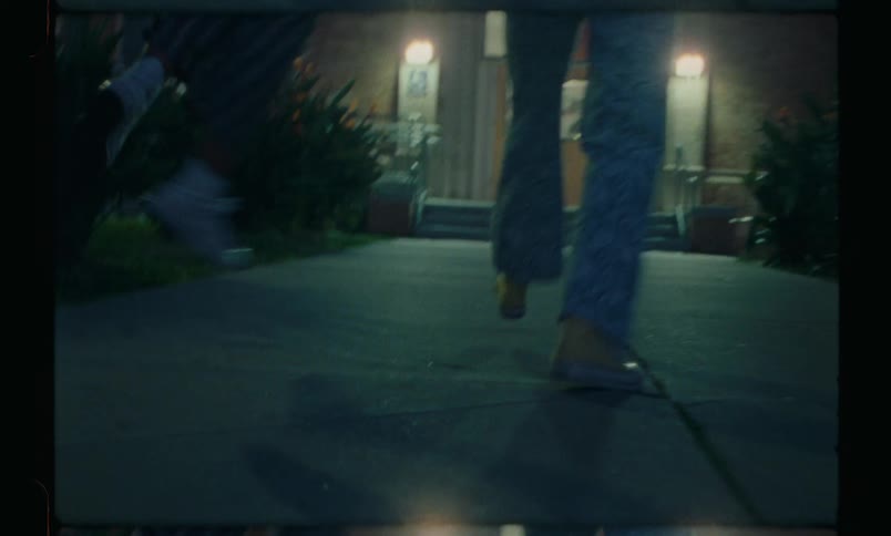 Three people jumping and walking along a path to a door