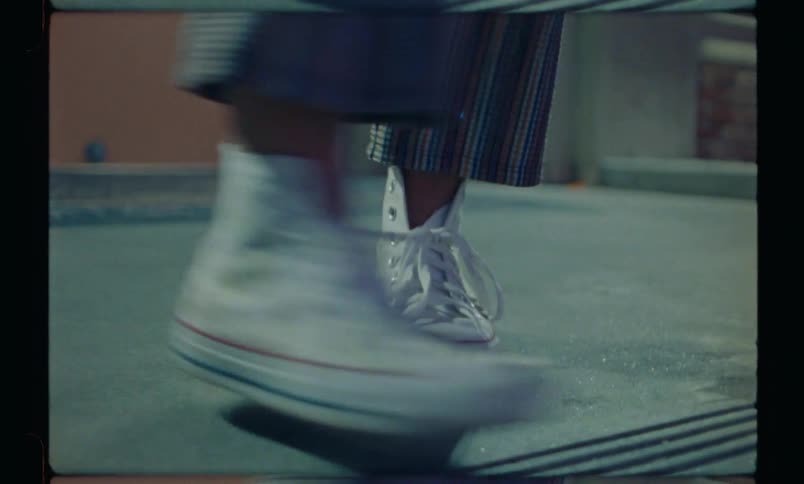 Friends wearing colorful shoes jump and play in a staircase outdoors