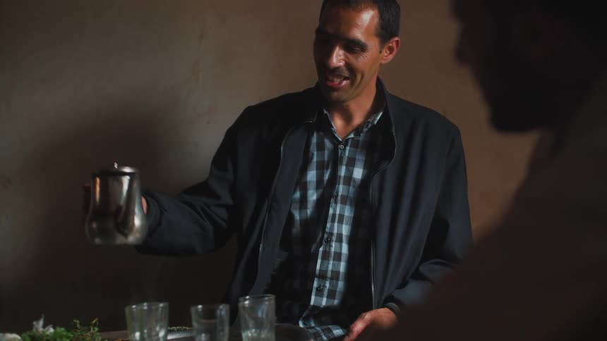 Man pouring a hot drink into a cup