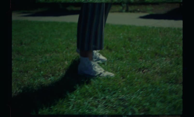 Legs of a person attempting a sideways somersault on the grass