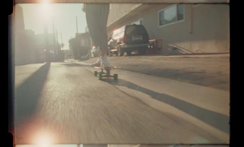 A woman rides her skateboard down the road