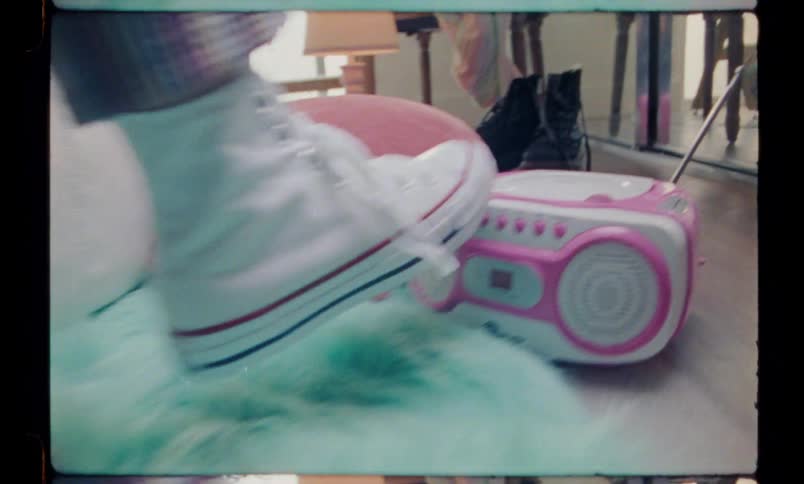 Person used a leg to press a button on a radio which is on the floor indoor