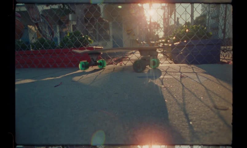 Skateboard moving on a tarred road at sunset