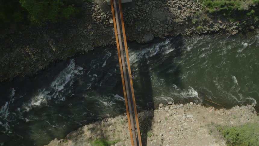 Birds eye view of a natural gas pipeline crossing above a river