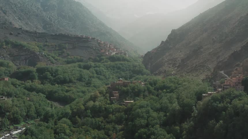 Mountainous landscape with dense greenery and a village perched on the hillside