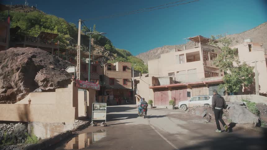 A motorcycle passing through a street in a city with old buildings