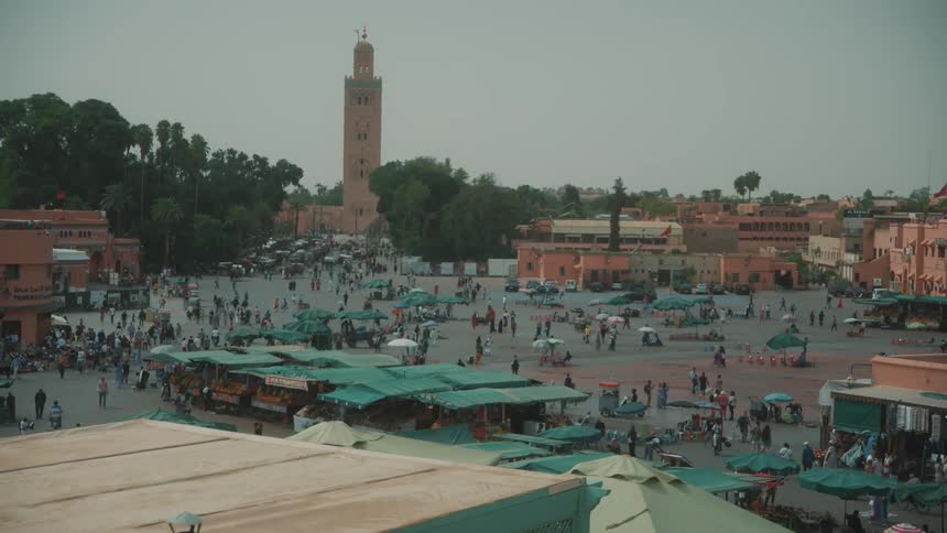 People moving around in a city square at dusk