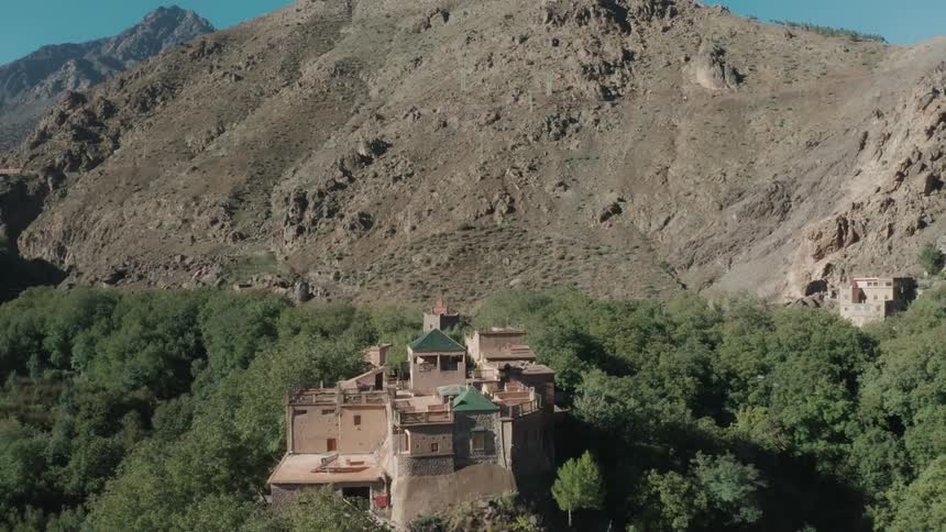 Aerial view of village houses and a mountain slope