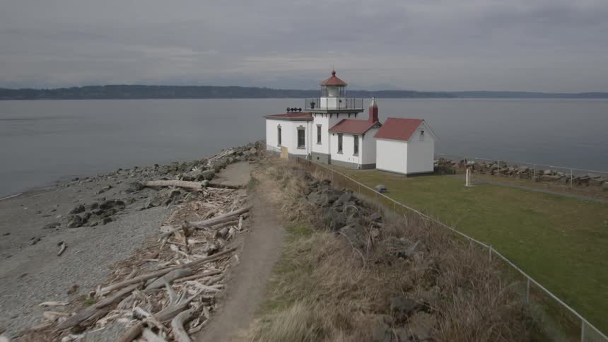 Pullback reveal of a lighthouse at the end of a narrow peninsula