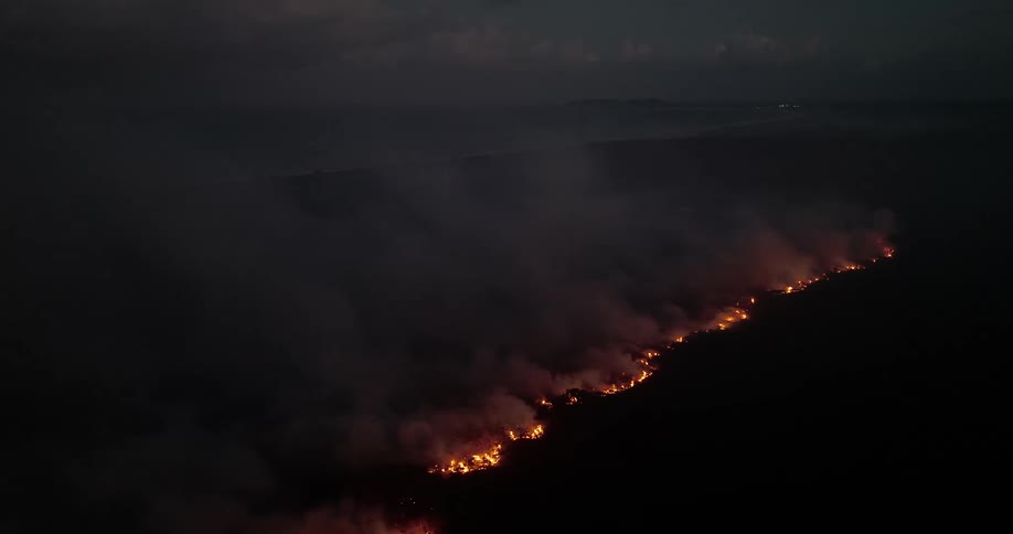 A rural region where the ground is with a band of fire burning everything