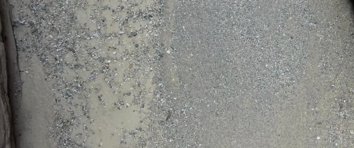 A sandy soil with several pebbles in the middle of a valley