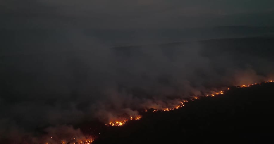 A natural region with a huge fire and smoke rising from the fire
