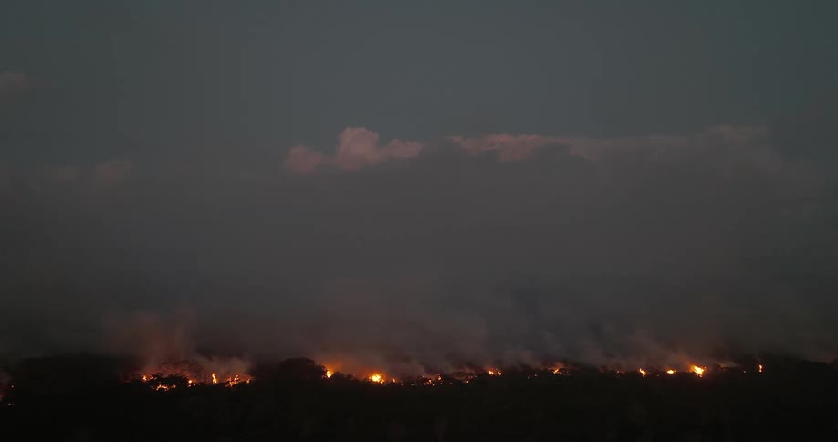 A land field is burning in flames as smokes goes up into the sky