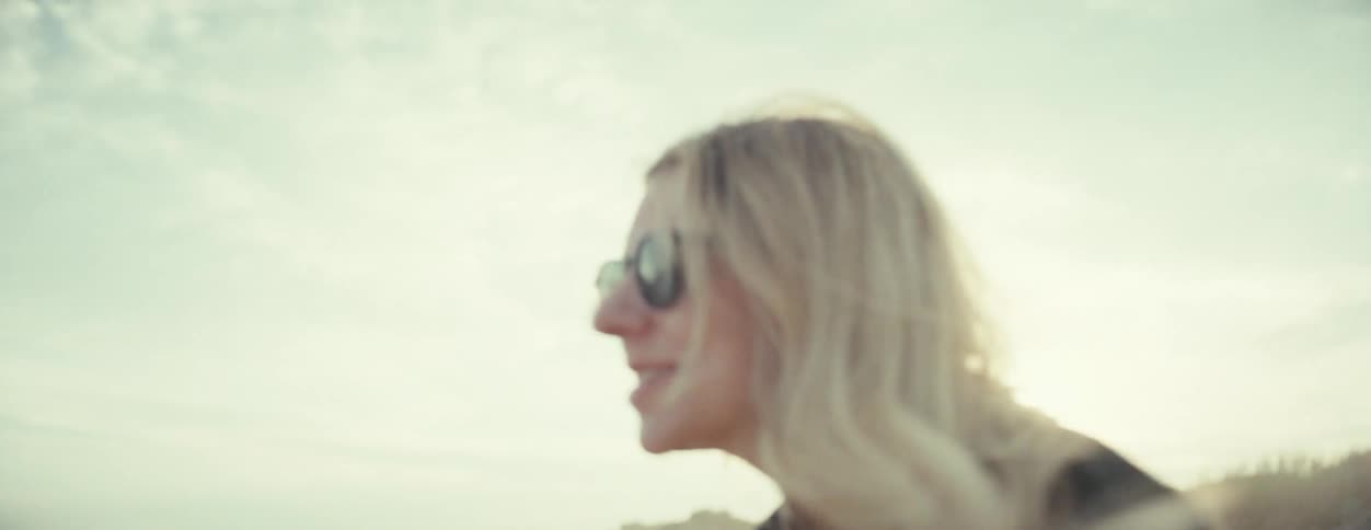 Happy blonde woman laughs and talks in the beach at morning