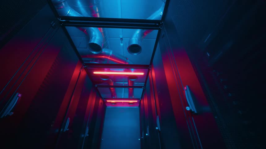 View of a server room metallic air vents and ducts lit by purple neon lights