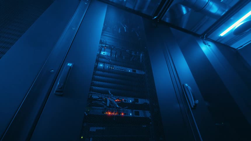 Small lights blink on server in room lit by blue lighting