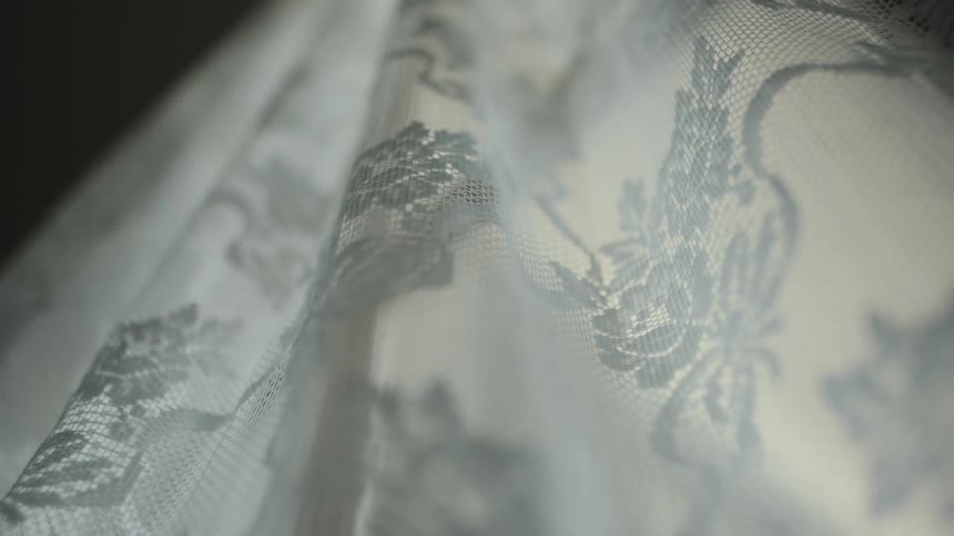 Lace curtain shifts slightly in the breeze