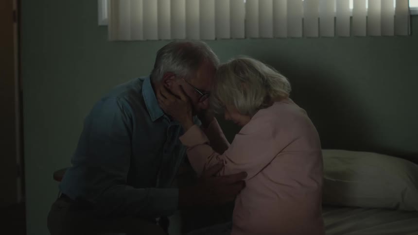 An elderly man and woman having a very affectionate moment