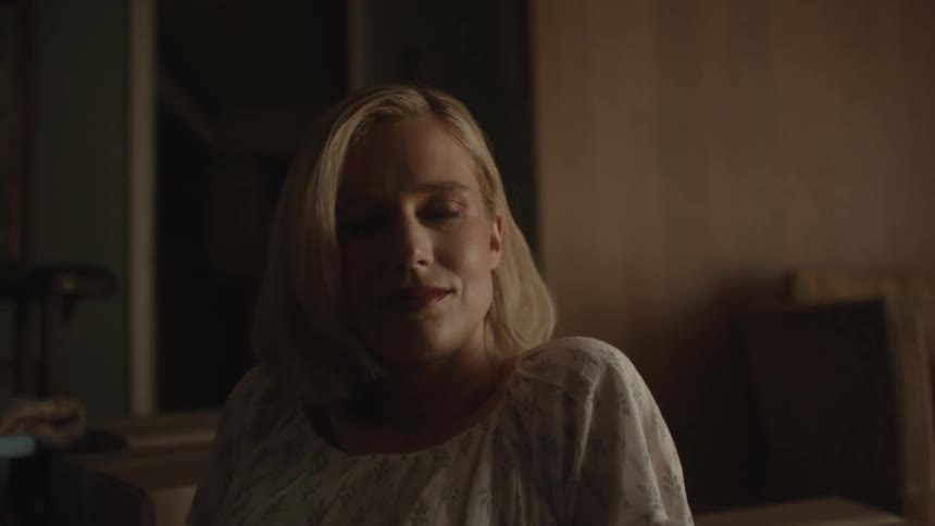 Blonde woman wearing a white dress listens to man attentively next to boxes