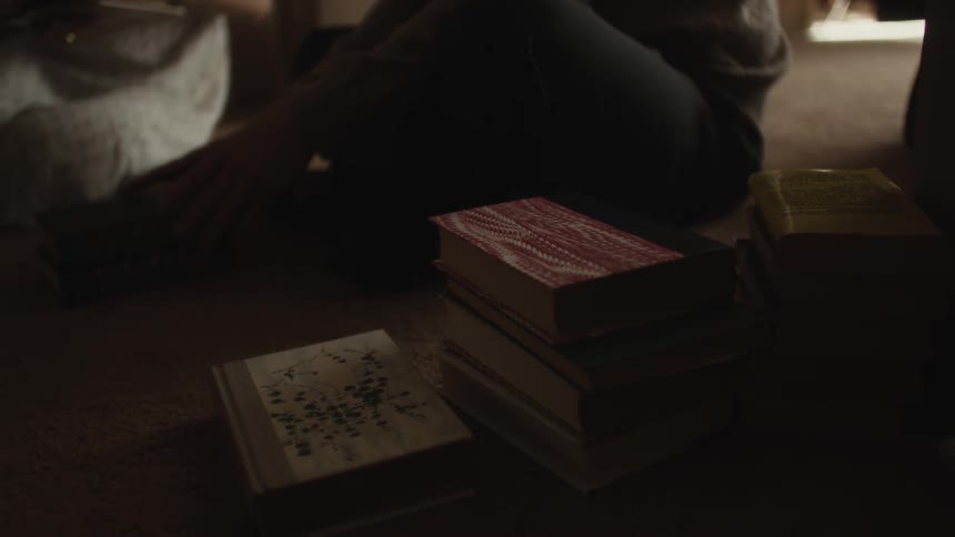 A woman reading a book to a man in the living room