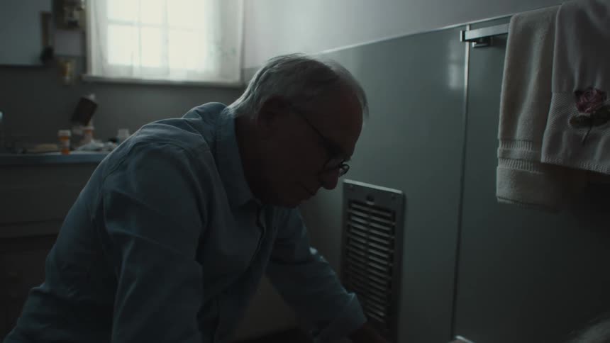 Elderly man washes back of woman sitting in tub