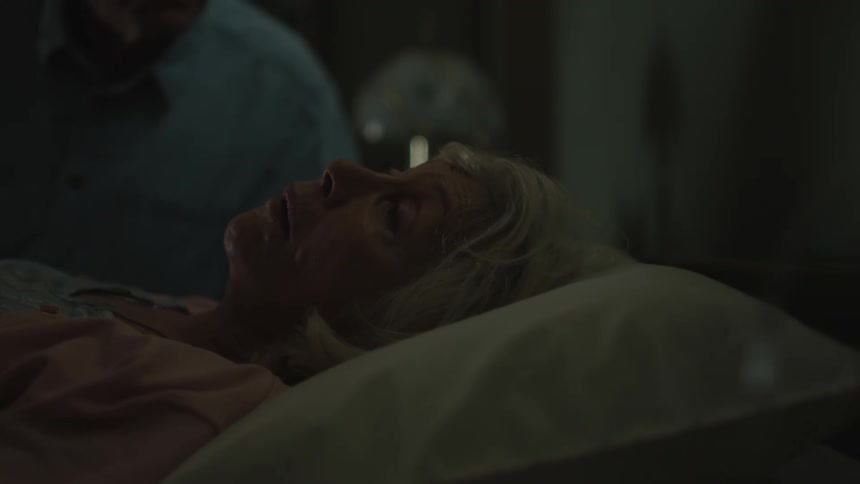 An old woman on the sick bed with her husband beside her