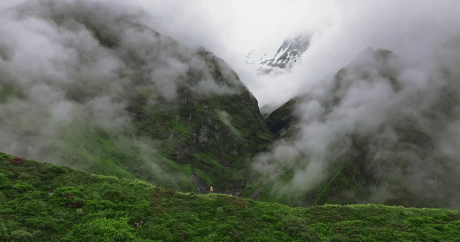 Skyline of a person walking on top of a mountain during a cloudy day