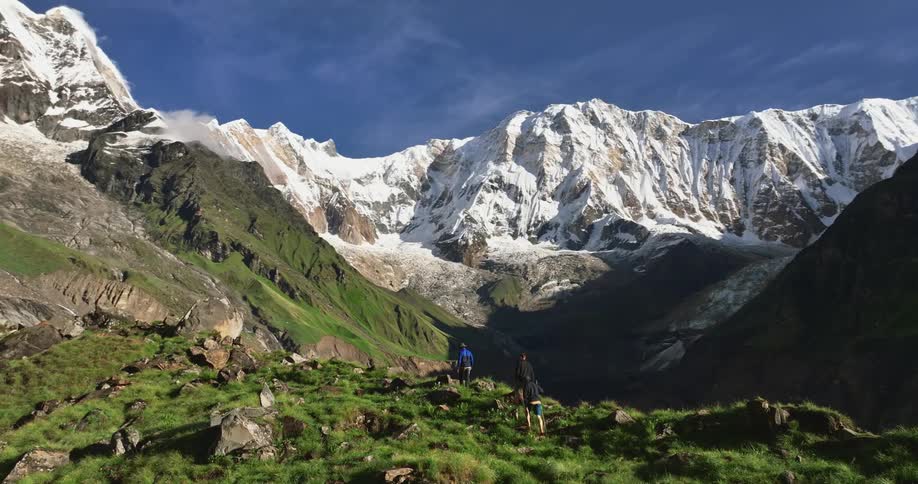 Three people are hiking atop a mountain