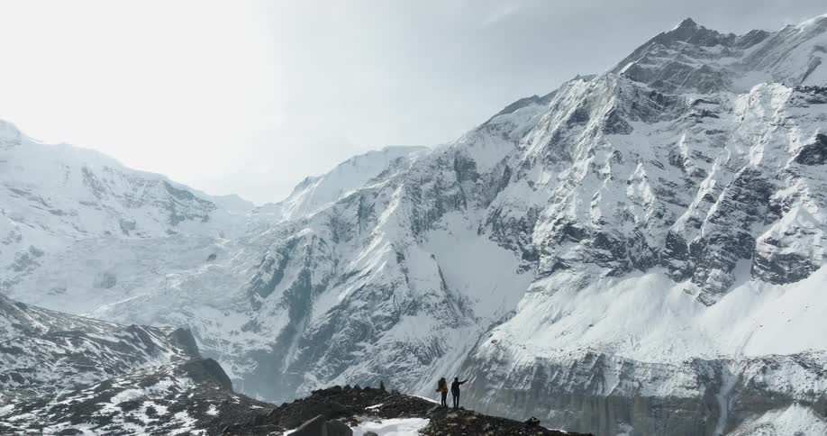 Two people looking at snowy mountain tops