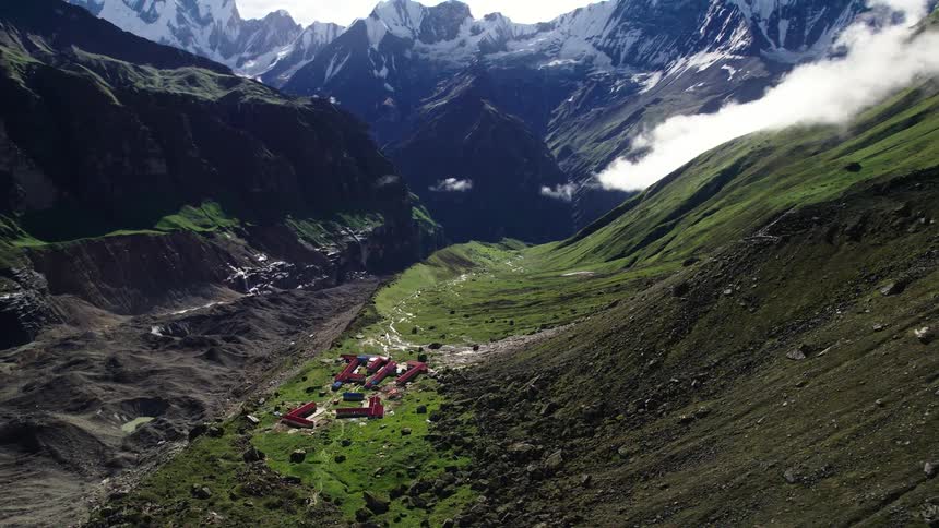 A small village down the mountain with a distance mountain covered in snow