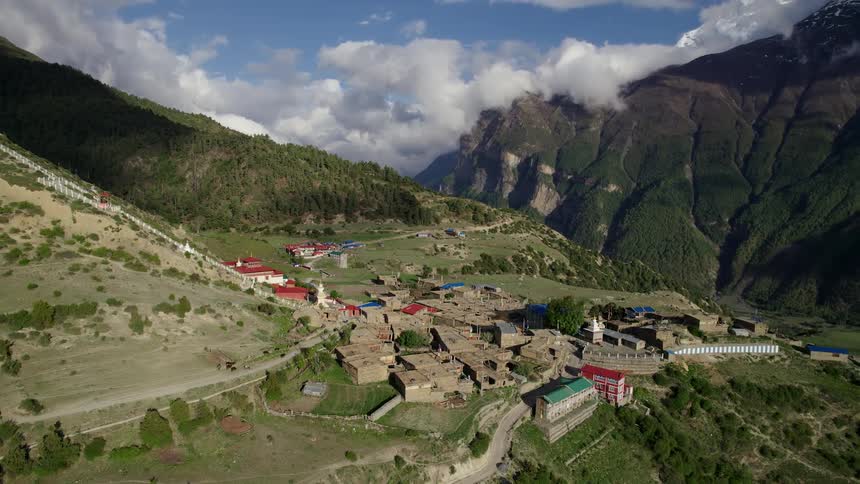 Aerial panorama of a village on a plateau surrounded by mountains