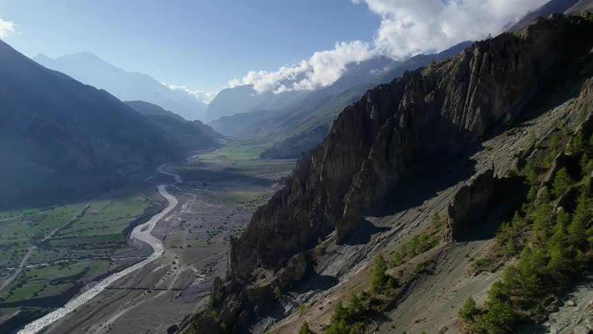 Aerial panorama of a natural area with a mountain range and a central river