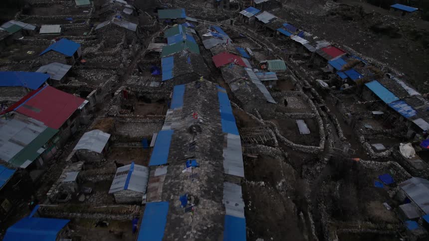 Village nestled on a plateau in the mountains under a cloudy winter sky