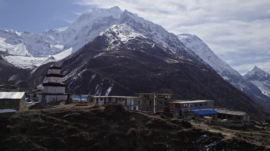The town is by the mountains covered in snow