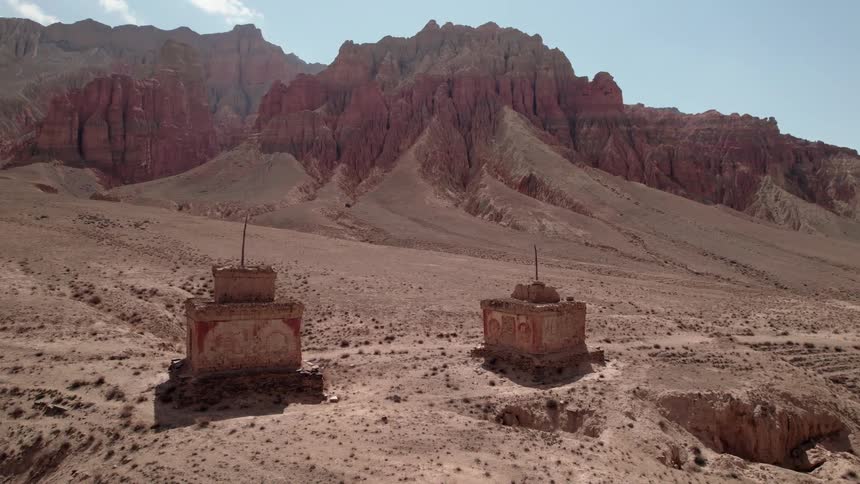 Aerial of ancient ruins in the desert with mountains