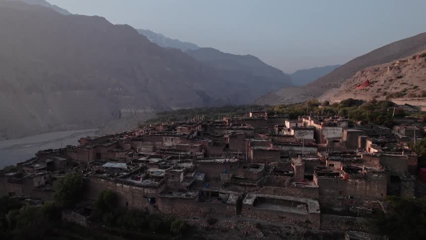 Aerial view of makeshift houses on mountaintops in a natural environment at sunrise
