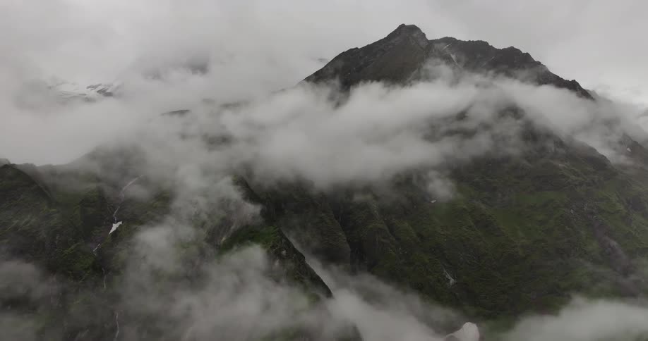 A mountain peak surrounded by clouds of fog
