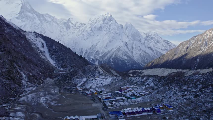 A small town surrounded by mountain covered in snow