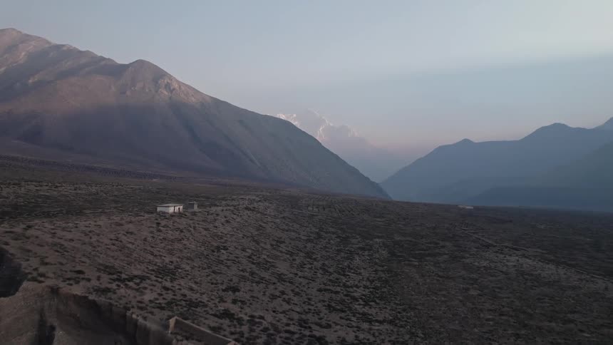 An aerial clip of a lone building in a mountainous desert