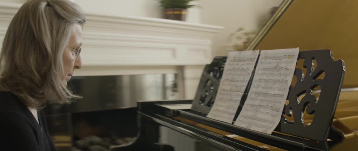A woman is sitting down playing the piano