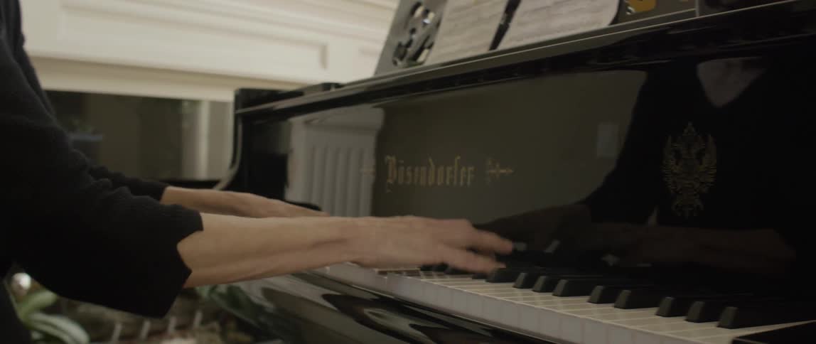 A woman is playing a piano near a chimney