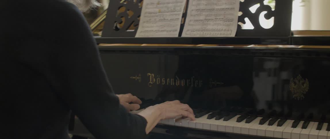 A woman is concentrating playing the piano