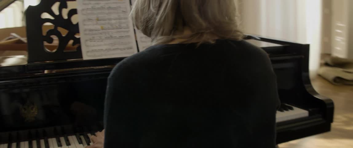 Spectacled woman playing her piano on a sunny day