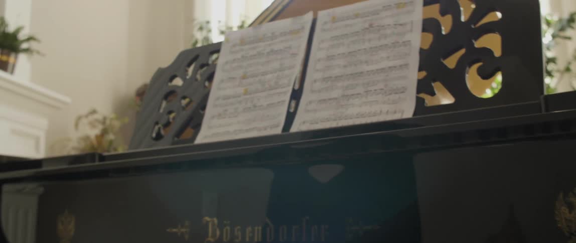 A woman sitting at a grand piano and playing