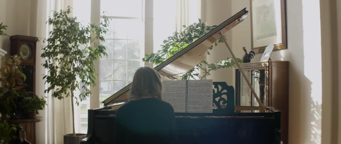 A woman is playing a piano