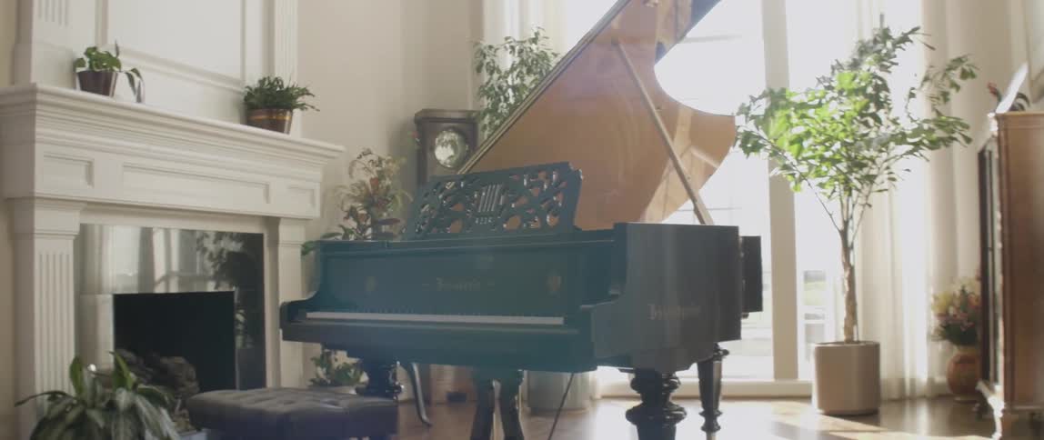 A large piano sits in a brightly lit room