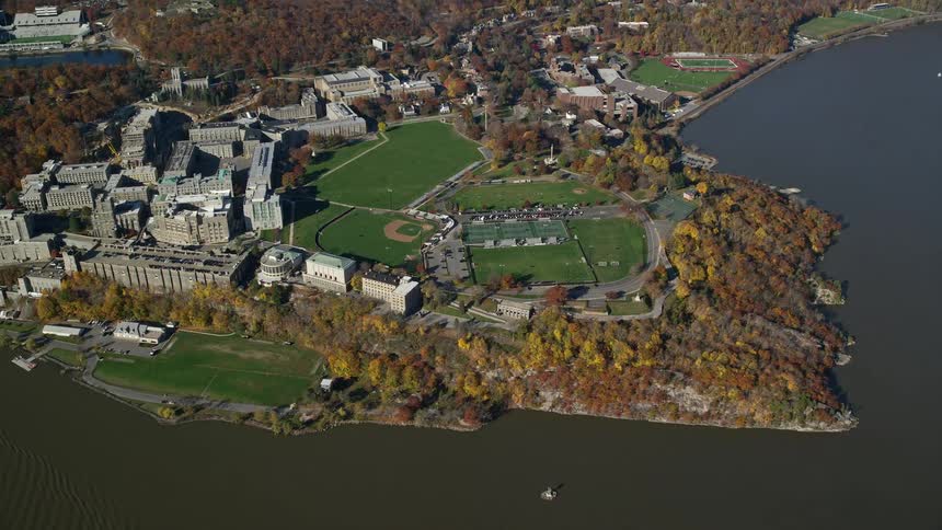 Aerial view of waterfront buildings green field and trees in fall color