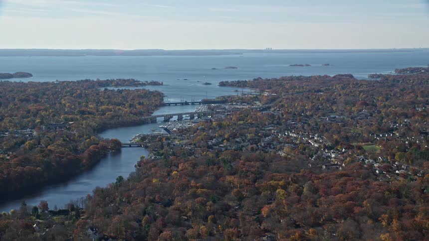An aerial view of a city that has a huge river in front that connects to the sea