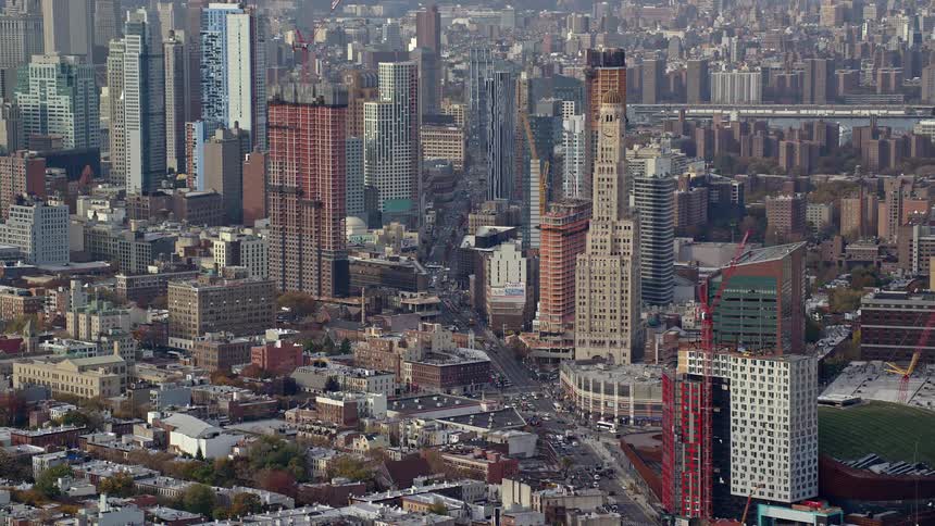 A metropolitan city with large buildings and several construction cranes