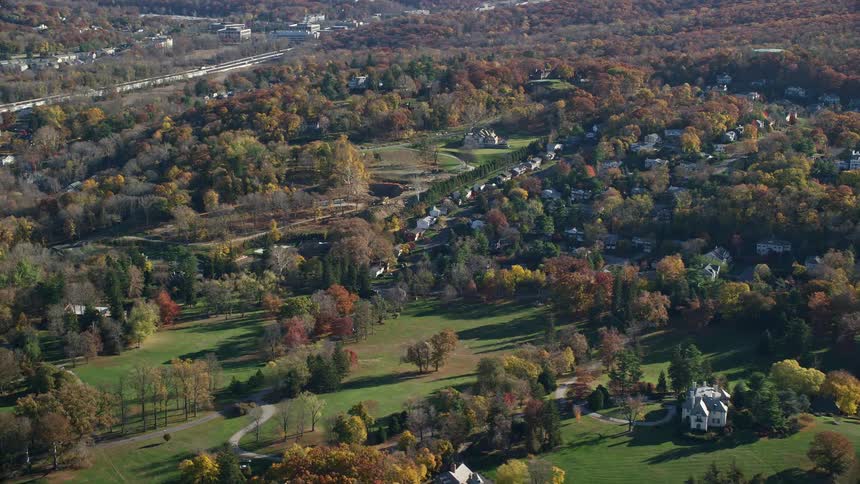 Aerial panorama of residential houses amidst natural fields with extensive vegetation